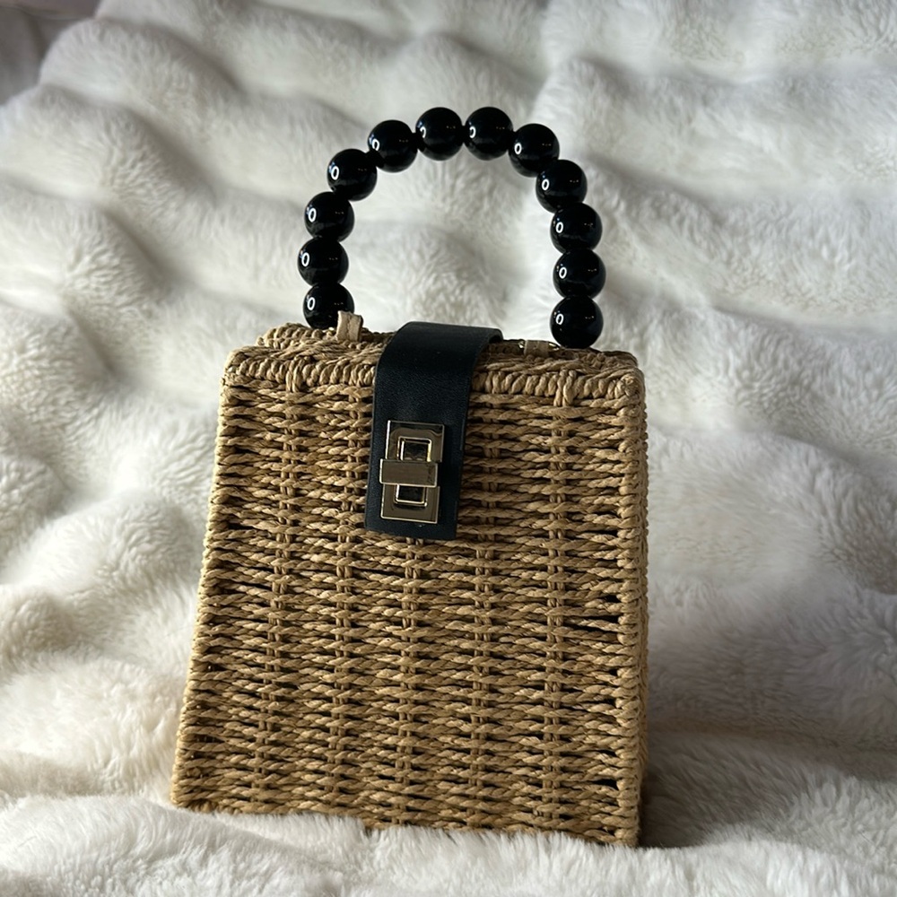 Tan raffia bag with black “pearl” detail